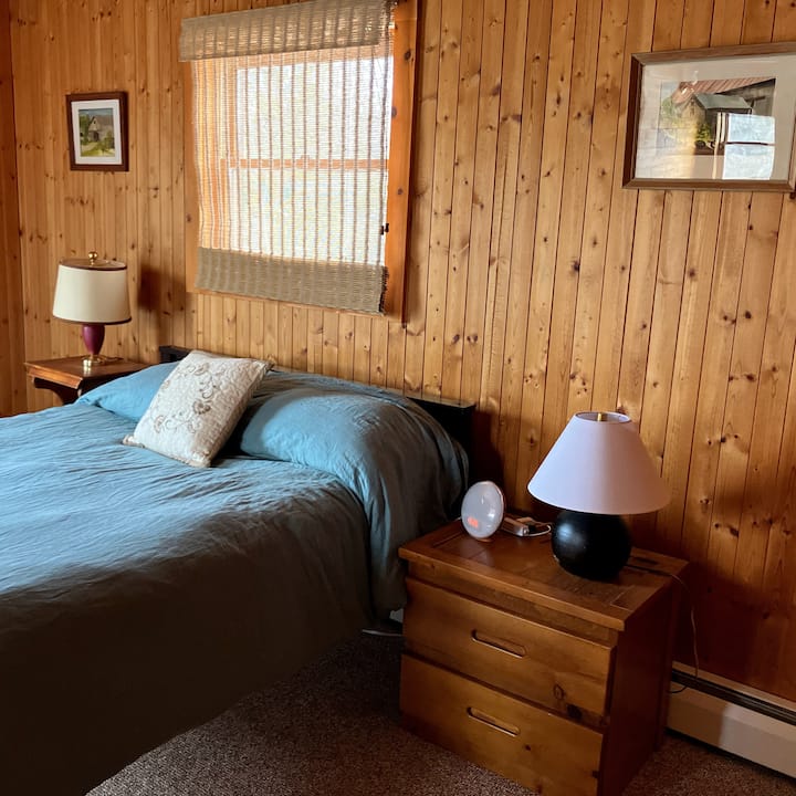 Plná posteľ a oddelené lôžko. Stôl v pracovnom priestore s výhľadom na Laughing Whitefish River.