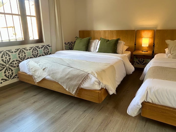 Habitación Chía: amplia y acogedora, con cama principal, cama sencilla, lencería blanca, textiles naturales y luz natural. Ideal para familias o grupos en Casa Sol de Iguaque.