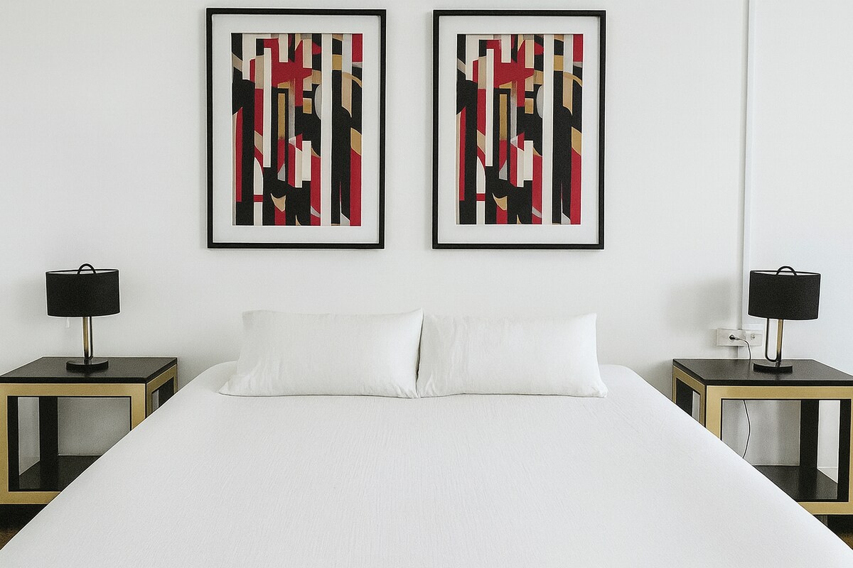 Amplio dormitorio orientado a la calle con ventanas coloridas y cortinas opacas para mayor comodidad.