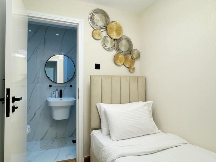 第三间卧室设有一张单人床、独立套房卫生间和宽敞的衣柜，非常适合单人房客或儿童入住。