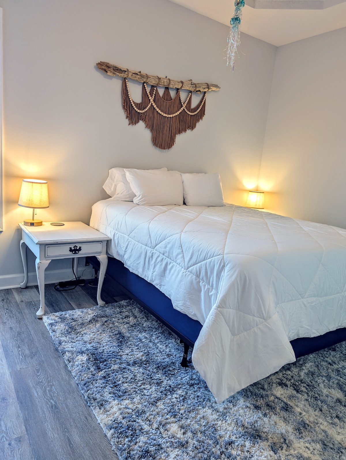 Relájate en el sereno dormitorio principal con una lujosa cama tamaño queen, iluminación suave y toques bohemios en la playa: tu retiro tranquilo después de un día de sol y surf.