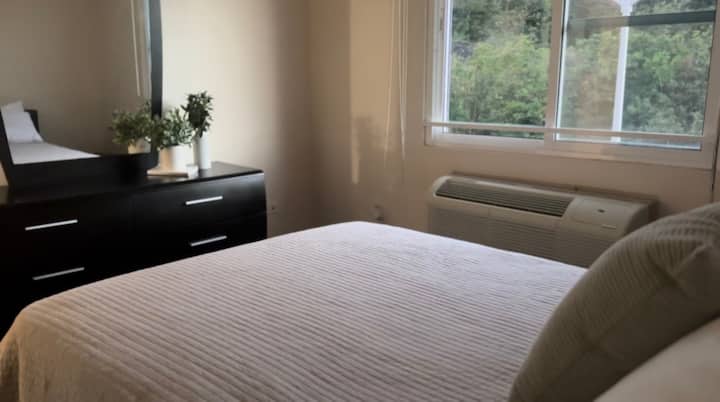 Cama queen suave con vista al bosque 