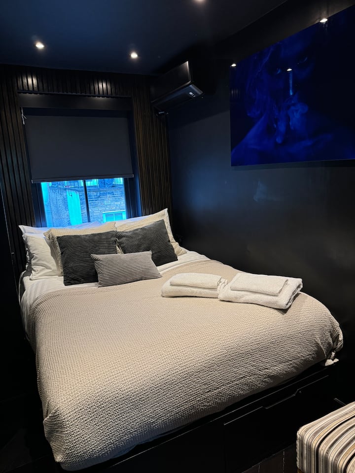 ห้องนอนขนาด 150x200 พร้อมตู้เสื้อผ้ากระจกมู่ลี่ไฟฟ้าสีดำและจุดชาร์จไฟข้างเตียงและจุดให้แสงสว่าง  พื้นที่ทำงานและเก้าอี้พับสำหรับผู้ที่ต้องการพื้นที่ส่วนตัวในการทำงาน ที่พักที่ออกแบบมาอย่างดีเพื่อการนอนหลับที่เงียบสงบ