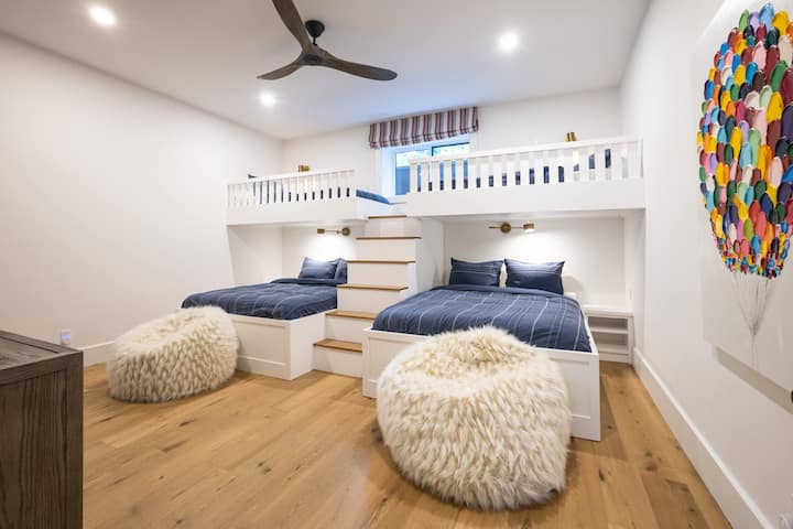 Chambre superposée ou club pour enfants ? 2 lits Queen size + 2 lits jumeaux XL. Téléviseur 75" avec système de jeu pour les journées « intérieures ».