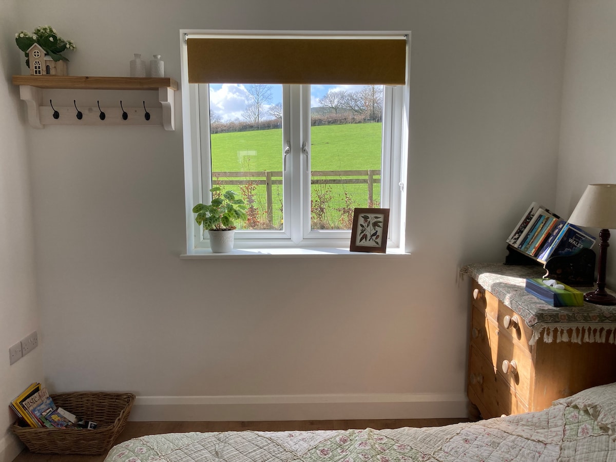 Cama doble con baño privado y vistas a las colinas. 