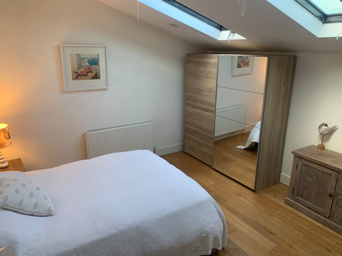 Светла, пространа спална соба во новиот дел од куќата, со прозорец Velux, дрвен под и голем гардеробер со огледало. Ова мирно прибежиште вклучува сопствена модерна бања со туш кабина за дополнителна удобност и приватност.