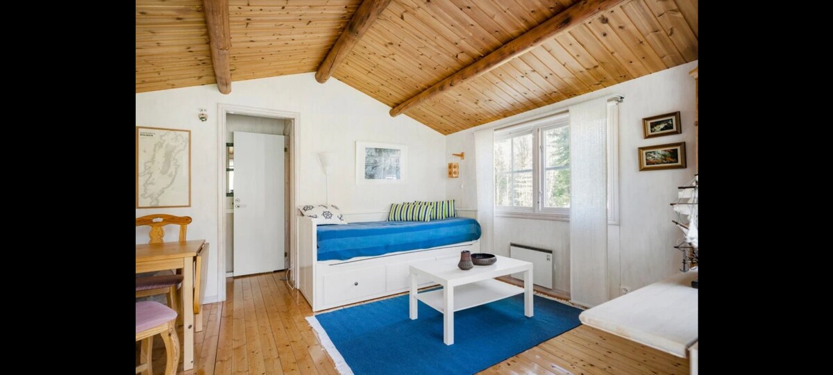 Lillstugan avec kitchenette, eau chaude/froide, toilettes, douche, table à manger et  canapé-lit pour 2 personnes. 