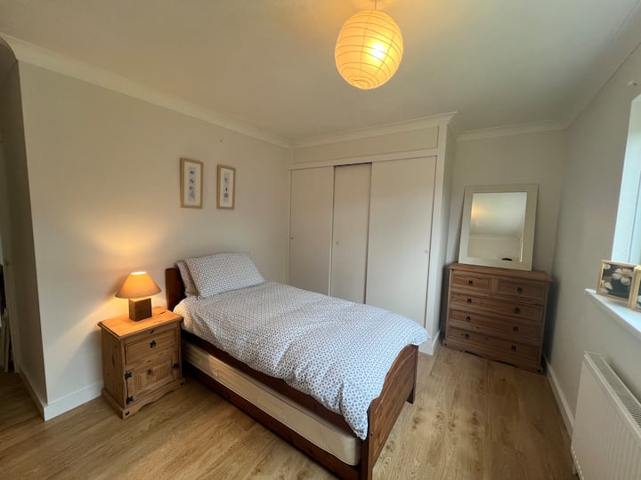 Два двокреветни/единечни кревета во пространа соба со плакар и фиоки во гардероберот. 