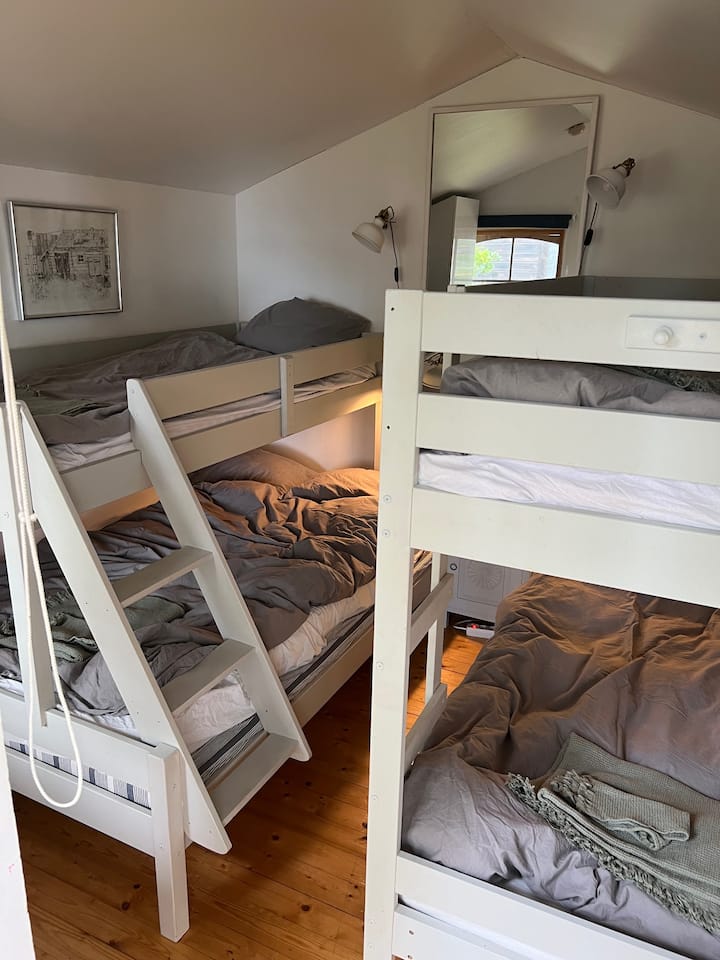По-стара спалня от 10 кв. м с 2 двуетажни легла (120+90 см и 90+90 см) и гардероб, както и място за съхранение в чекмеджета под леглата (не са включени, когато е направена снимката).