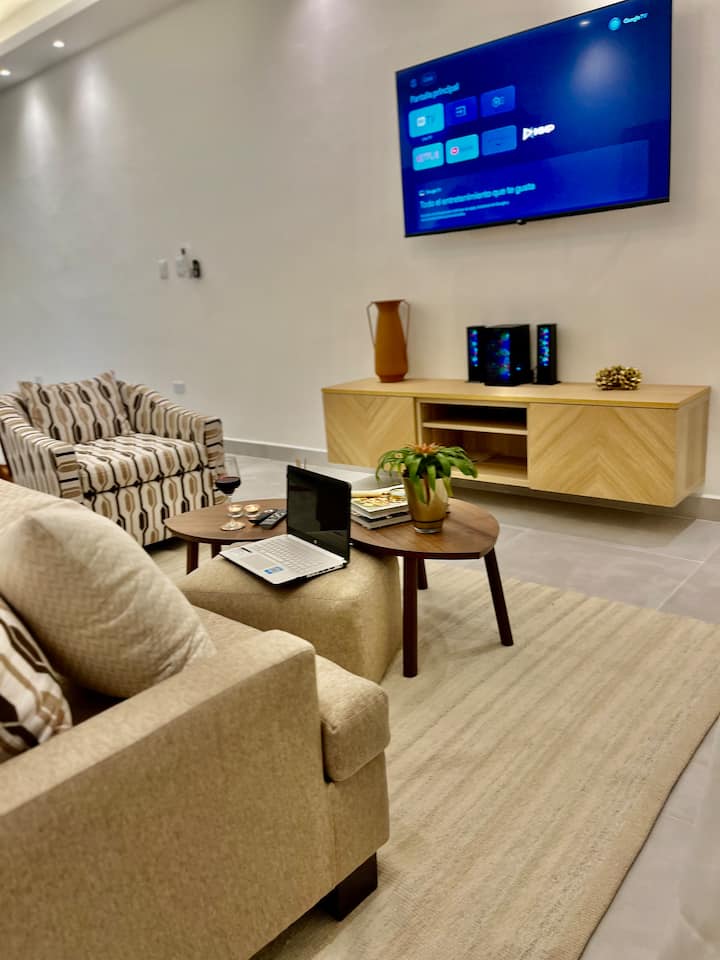 Soggiorno dal design esclusivo con arredi raffinati, Smart TV, impianto audio, aria condizionata e vista panoramica sulla città.
