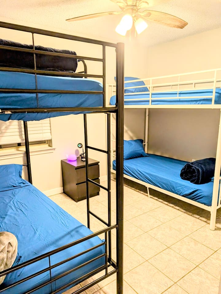 Toni za pwani na matandiko ya kifahari huunda mapumziko yenye upepo mkali, yenye msukumo wa ufukweni, kila kitanda kina godoro la hali ya juu kwa ajili ya kulala kwa utulivu na starehe ya kupumzika.