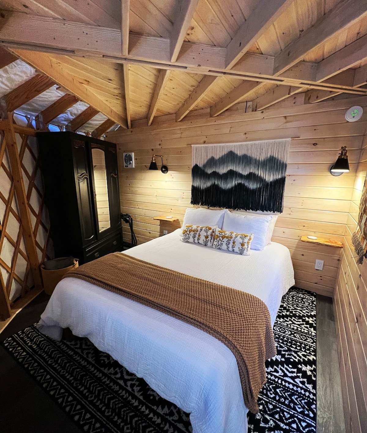 The main bedroom features a queen size hybrid mattress, large armoire, two large windows providing natural lighting and connection with nature even indoors! Find suitcase holders, shelving and plenty of outlets for your convenience! 