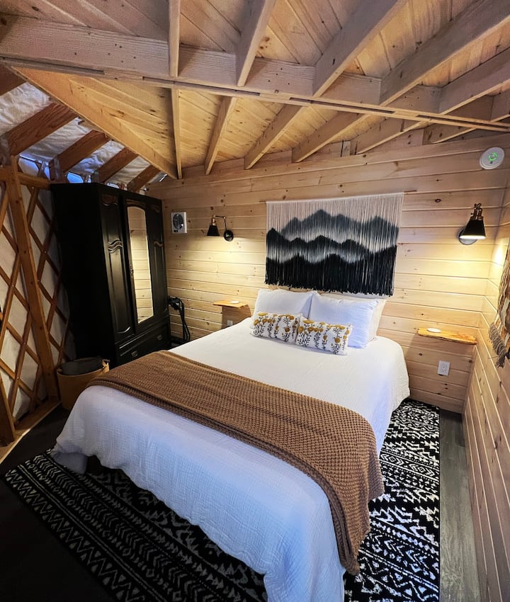 The main bedroom features a queen size hybrid mattress, large armoire, two large windows providing natural lighting and connection with nature even indoors! Find suitcase holders, shelving and plenty of outlets for your convenience! 