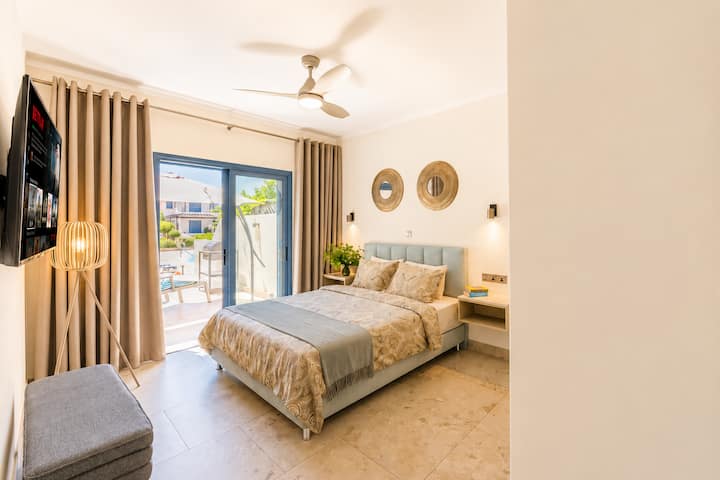 Chambre principale élégante • Lit queen de 160 × 200 cm • Matelas de qualité hôtelière haut de gamme • Téléviseur intelligent • Rideaux occultants • Miroir pleine longueur • Toilettes et lavabo privés attenants • Vue sur le jardin paisible et la terrasse • Climatisation