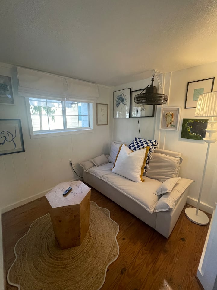 توفر الأريكة الكبيرة القابلة للسحب استخدامًا مرنًا لمساحة النوم والتسكع، والتلفزيون مقابل الجدار من الأريكة