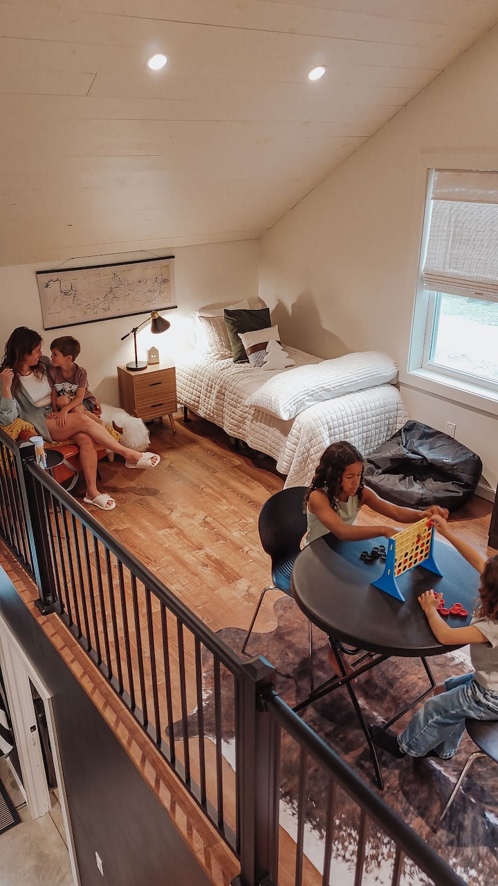 Additional sleeping area in the loft including two twin beds and armoire filled with games. 