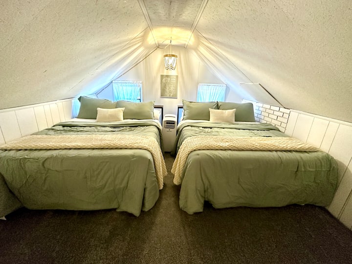 Walk up the very steep attic space and you will discover two rooms (no privacy doors). Room one features two queens and 2 twins. This photo shows our two queen beds outfitted with extra pillows and blankets. 