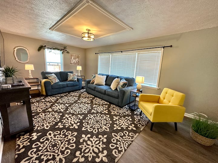 The living room is directly to the right of the front door. It features a couch, love seat, and chair. It also has a 55” smart TV so you can log in to your favorite streaming account and watch your favorite shows!