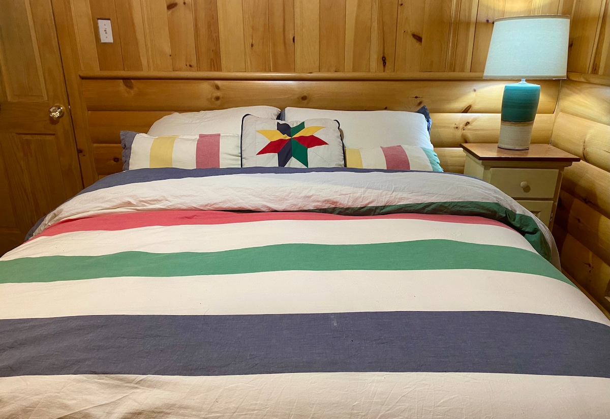 Iko kwenye ghorofa kuu chumba hiki cha kulala chenye nafasi kubwa na ufundi wa kipekee kina dari iliyopambwa, boriti iliyo wazi, feni ya dari, kitanda cha ukubwa wa malkia chenye starehe kilicho na mashuka ya kifahari ya HBC, kabati, kabati la kujipambia na mwonekano mzuri wa msitu! 