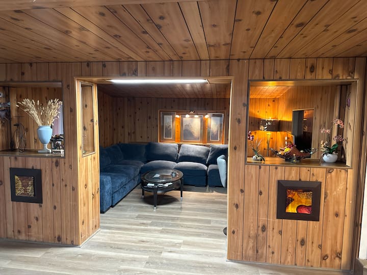 The living room is a very comfortable and warm place. There is a 65-inch Samsung TV and a very large sofa. The sofa can be pulled out to become a bed, and it feels very comfortable to sleep on it.