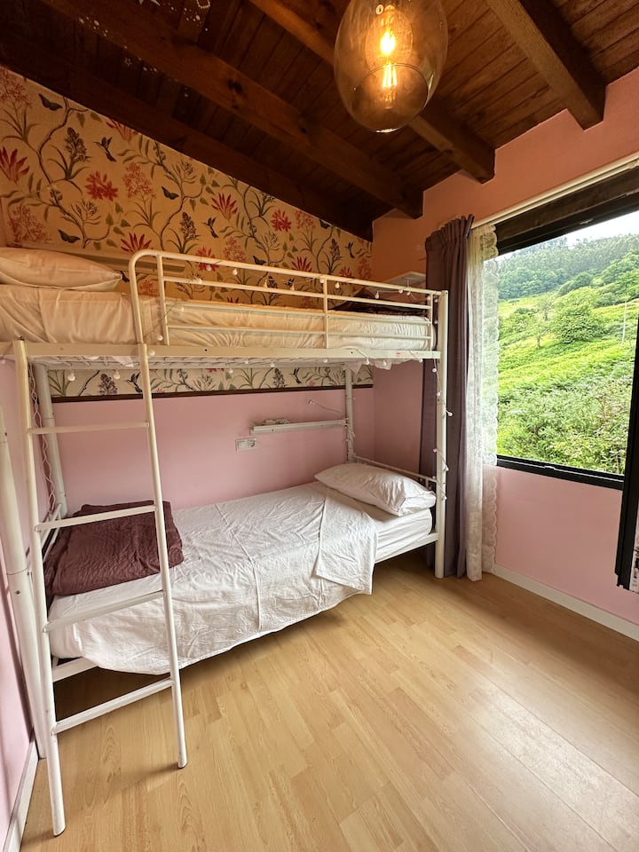 Habitación luminosa con litera metálica, perfecta para niños o jóvenes. Un espacio acogedor con mucho encanto.