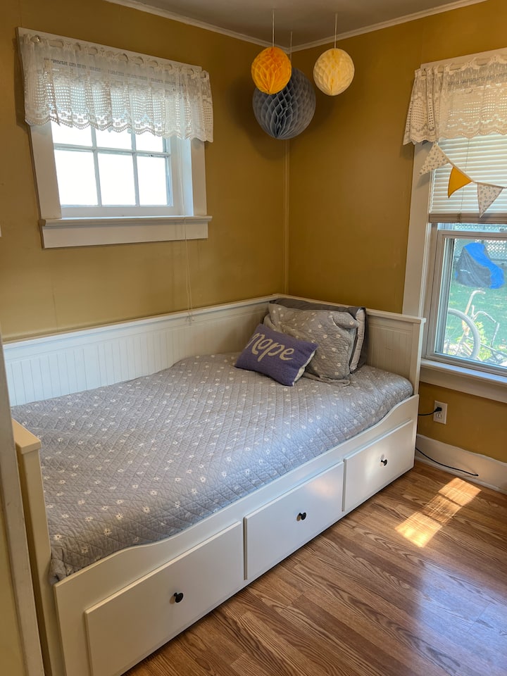 Acogedor dormitorio con cama individual y cajones de almacenamiento.