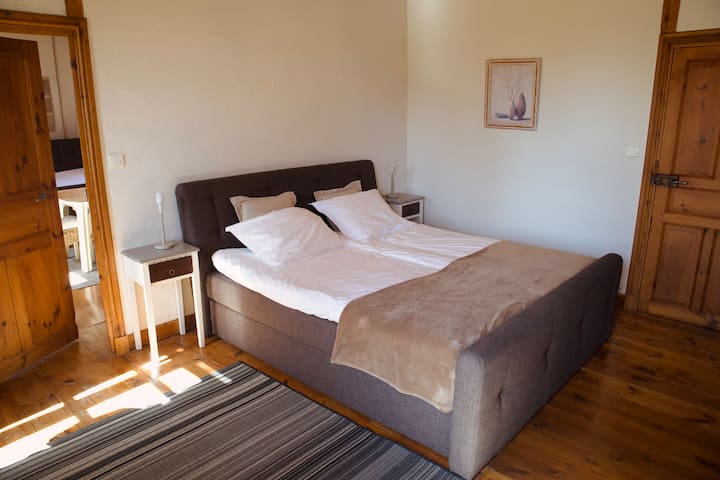 Chambre avec lit King Size à sommier tapissier, attenante à la chambre du studio, rangement pour les vêtements