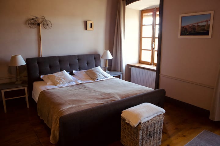 Chambre avec lit King Size à sommier tapissier, accès à la salle de bain et kitchenette privée