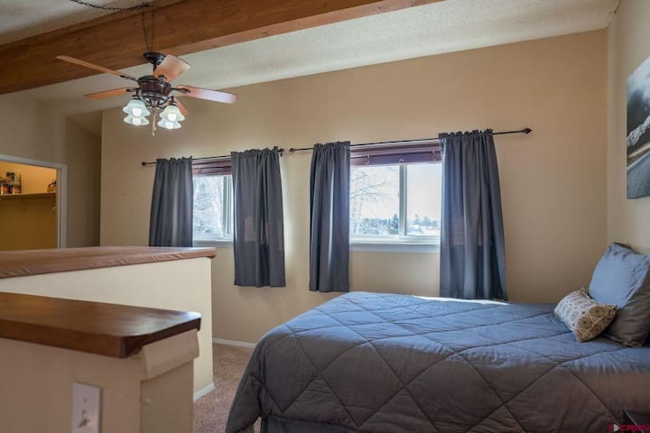 Obývacia izba 2 je náš loftový priestor. Nemá typické 4 steny a dvere, ale je odľahlá, má veľa prirodzeného svetla a všetko pohodlie spálne vrátane manželskej a jednolôžkovej postele, nočných stolíkov, lámp, stropného ventilátora a skrine.