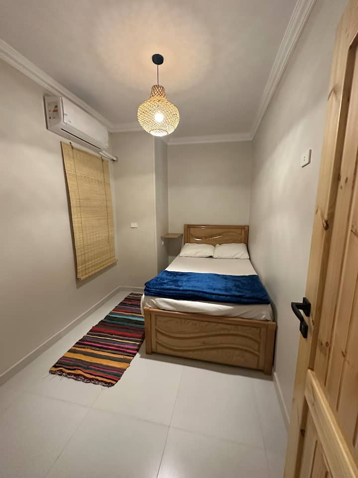 La primera habitación incluye una cama individual, un colchón en el suelo, un estante junto a la cama, un perchero y un escritorio que se abre desde el lado derecho trasero.