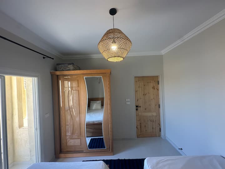 Este dormitorio incluye dos camas individuales, una mesita de noche, un armario con estantes y perchas, fundas nórdicas adicionales para las noches frías y un hermoso balcón. Los muebles de exterior aún no están disponibles.