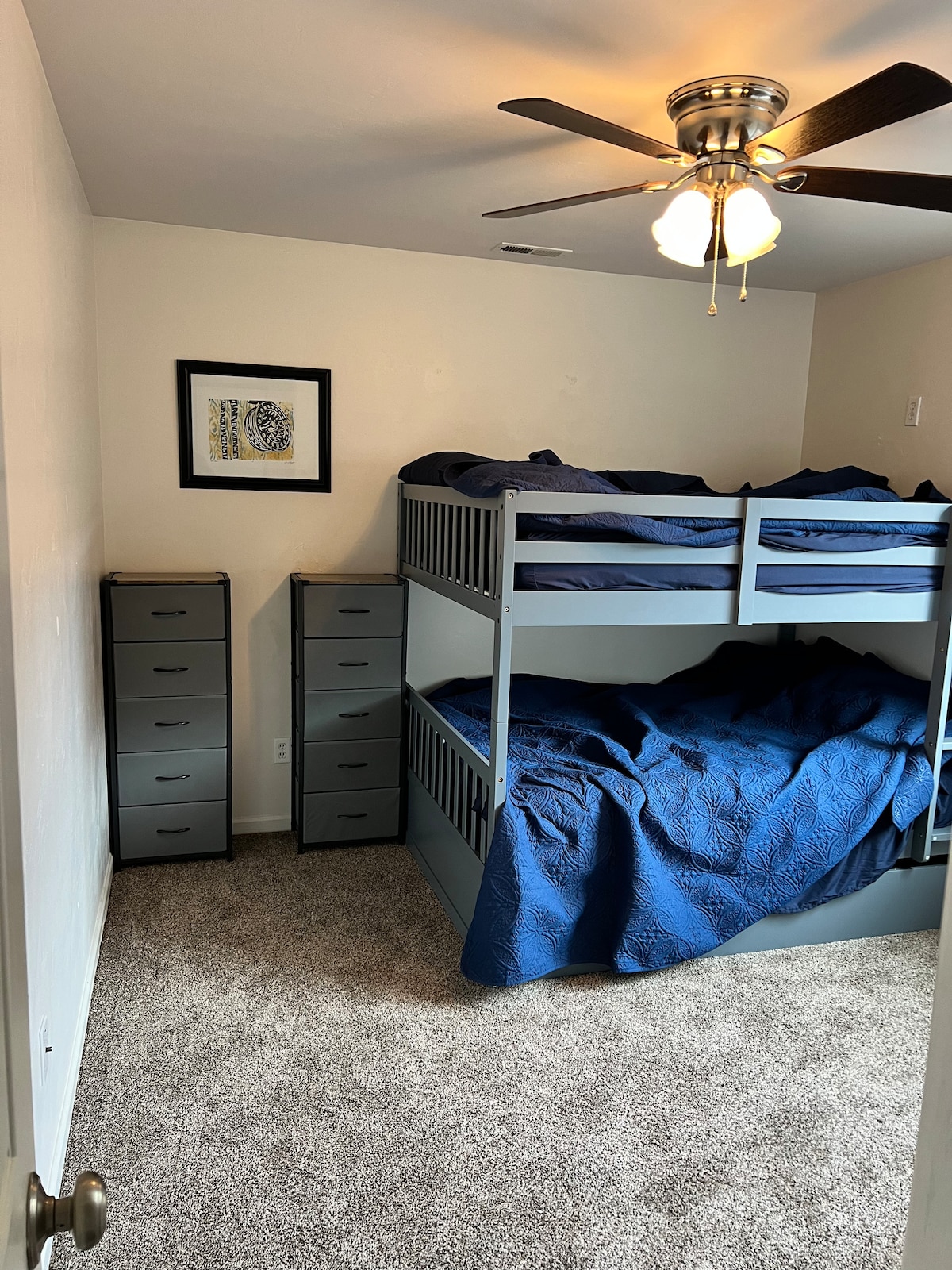 Full over full bunk beds with a twin mattress trundle (mattress in closet). Ceiling fan and tall dressers plus a luggage rack.