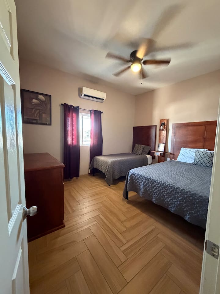 Chambre spacieuse avec 2 lits confortables (grand lit et lit simple) dotés de matelas en mousse à mémoire de forme, d'une commode, de tables de chevet avec ports de recharge USB et USB-C et d'un climatiseur mini-split silencieux. Parfaite pour se détendre et profiter d'un séjour reposant. ️✨