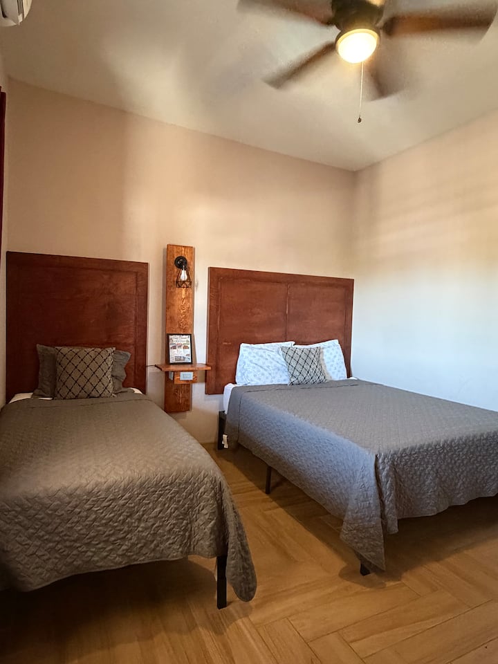 Chambre spacieuse avec 2 lits confortables (grand lit et lit simple) dotés de matelas en mousse à mémoire de forme, d'une télévision intelligente, d'une commode, de tables de chevet avec ports de recharge USB et USB-C et d'un climatiseur mini-split silencieux. Parfaite pour se détendre et profiter d'un séjour reposant. ️✨