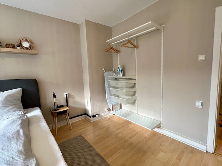 Glavna spavaća soba s glačalom i daskom za glačanje i otvorenim ormarom