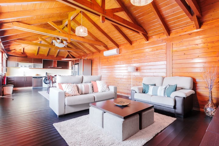 The living room has two sofas, one of which is a sofa bed, and a large wall-mounted Smart TV.