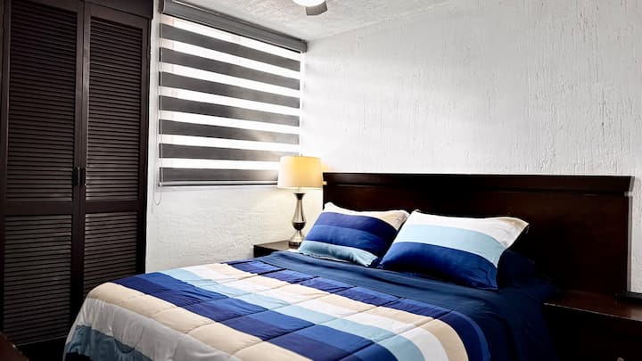 Няма да искате да станете от това легло. Главната спалня разполага с двойно легло, нощна лампа, тъмни завеси, вентилатор и достатъчно място в гардероба и мебелите.