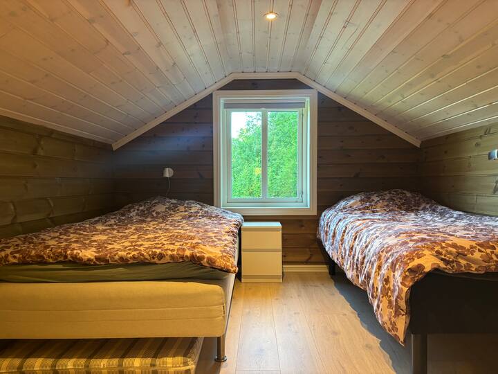 საძინებელშია 120‑სმ‑იანი საწოლი, 90‑სმ‑იანი საწოლი და დამატებითი ლეიბი. კომოდი და ორი ტუმბო საწოლთან.