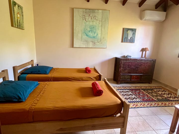 Chambre double confortable avec climatisation et sa salle de bain avec toilette.