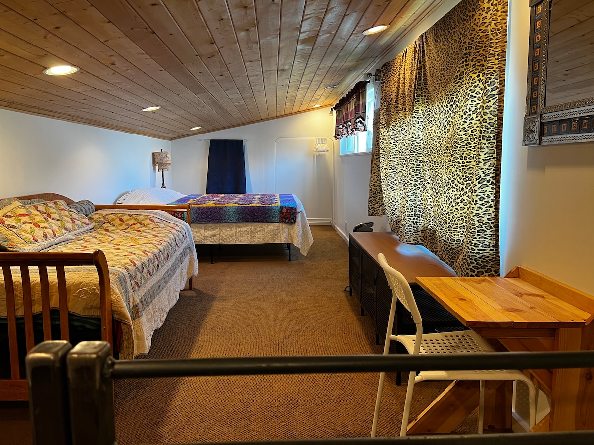 Loft de arriba. Tiene una cama tamaño queen. Cama/sofá cama doble. Y pequeño área de escritorio. Perchas y perchas para ropa. 