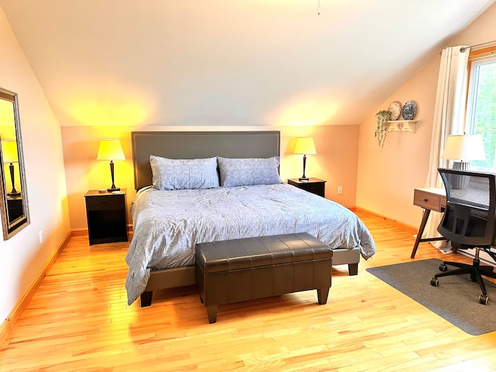 استرخ في غرفة النوم الرئيسية الهادئة التي تحتوي على سرير كينج مجهز بمرتبة ستيرنز وفوستر فاخرة تكملها طاولتين نوم أنيقتين. استمتع بملاذ واسع ومريح مثالي لليالي المريحة وتجديد شباب الصباح.