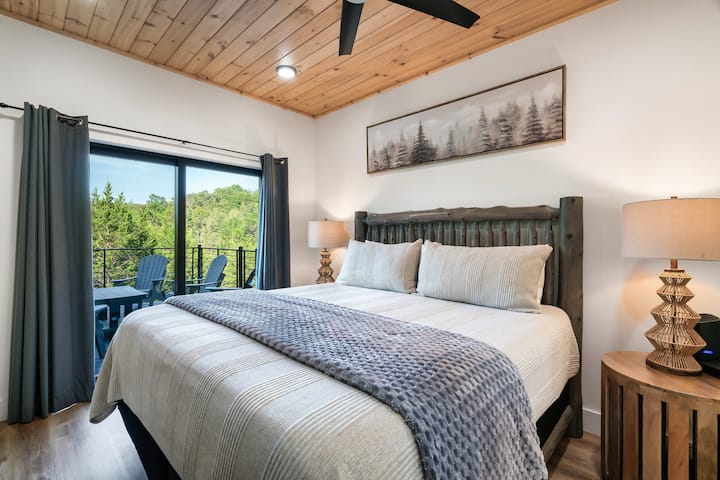 Quarto principal com cama king size, acesso privativo à varanda e ao lado da área de estar principal. Tem despertador, ventilador de teto, TV, cobertor e banheiro grande com chuveiro.