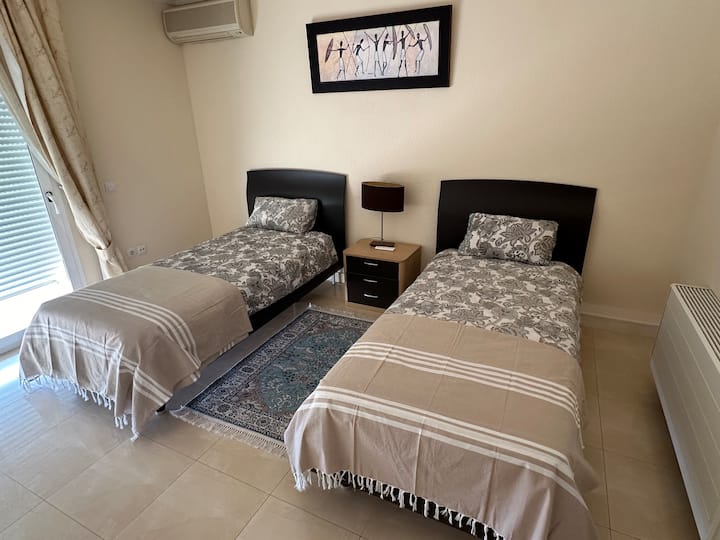 2 samostatné postele s výhľadom z okna na oceán.