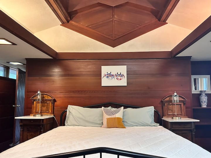 Magnificent master suite from the original custom build in 1963. Custom woodwork and skylights. High end and supportive king bed, flanked by antique nightstands.