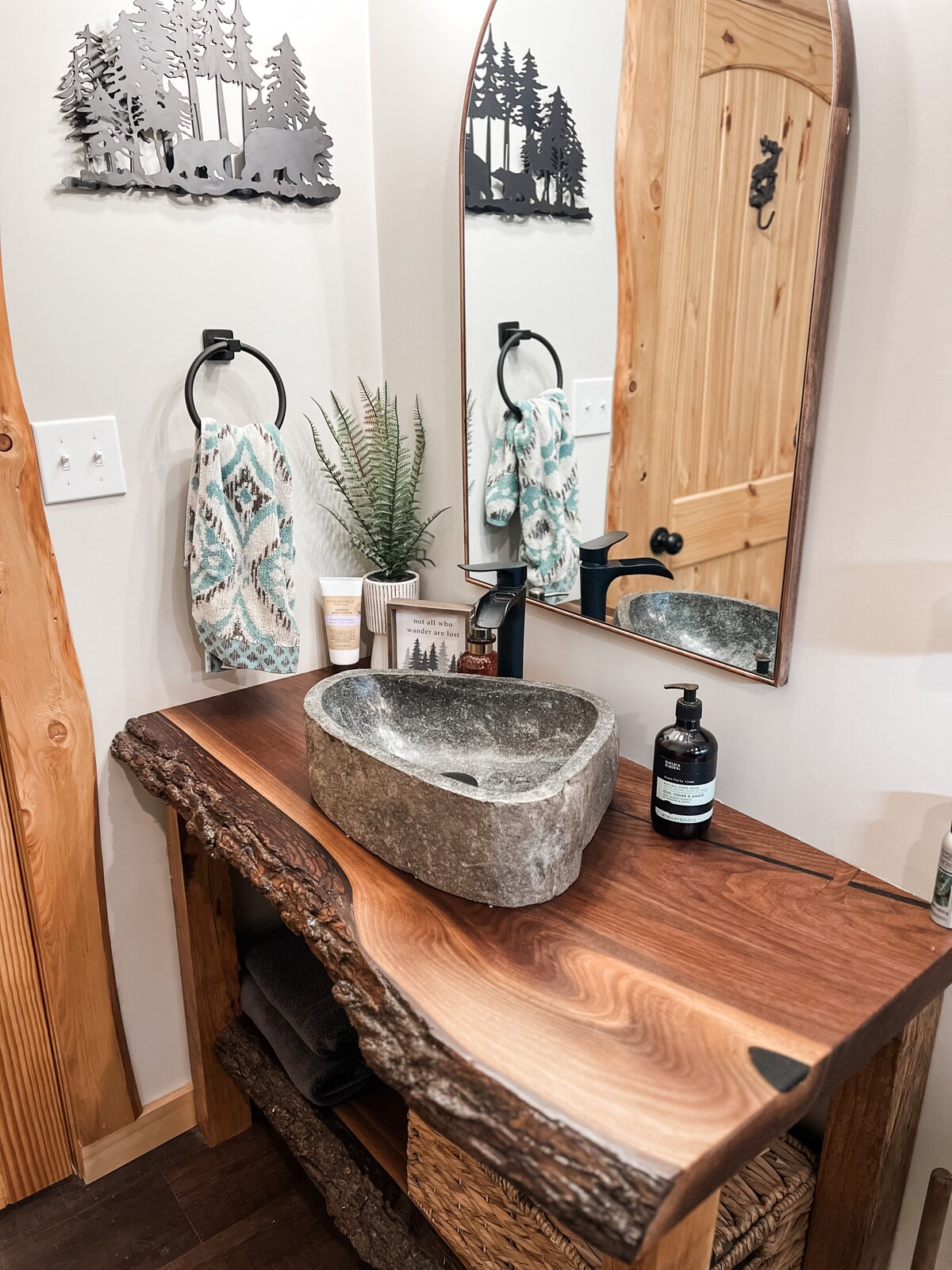 Black Walnut live edge vanity with black epoxy infill, bowties and a granite stone sink. at Sweet River Lodge in Tionesta