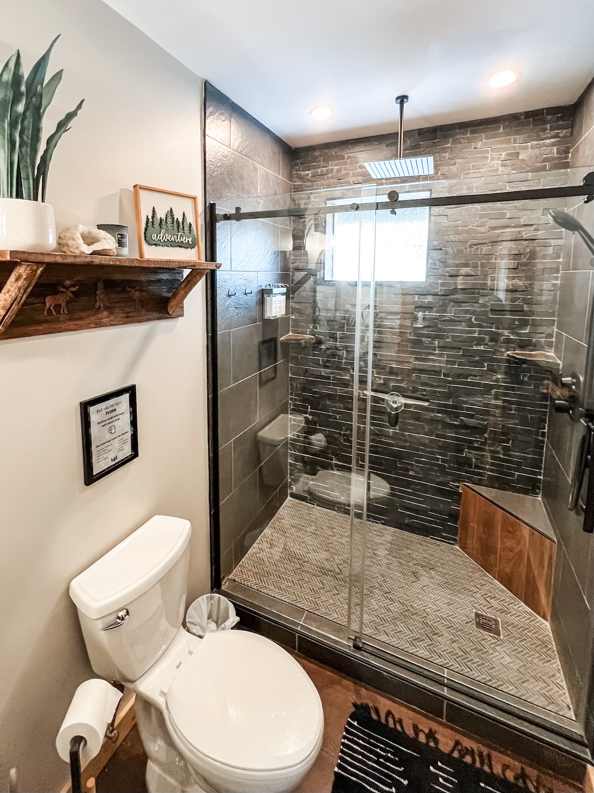The shower features a rain head and a wall mount handheld head with locally sourced stone shelves from Little Tionesta Creek at Sweet River Lodge in Tionesta