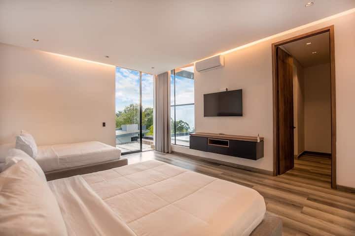 Dos lujosas camas con sábanas de calidad hotelera te esperan en esta configuración perfectamente simétrica, ideal para compartir sin sacrificar la comodidad o la privacidad.
