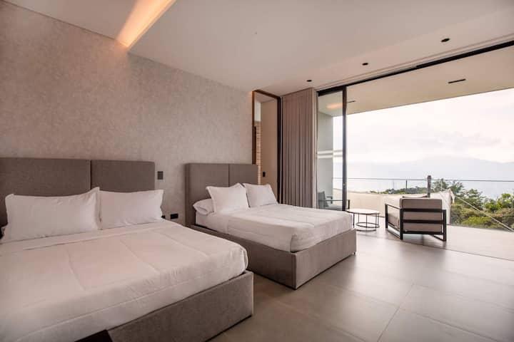 Two luxurious beds with hotel-quality linens await in this perfectly symmetrical setup—ideal for sharing without sacrificing comfort or privacy.