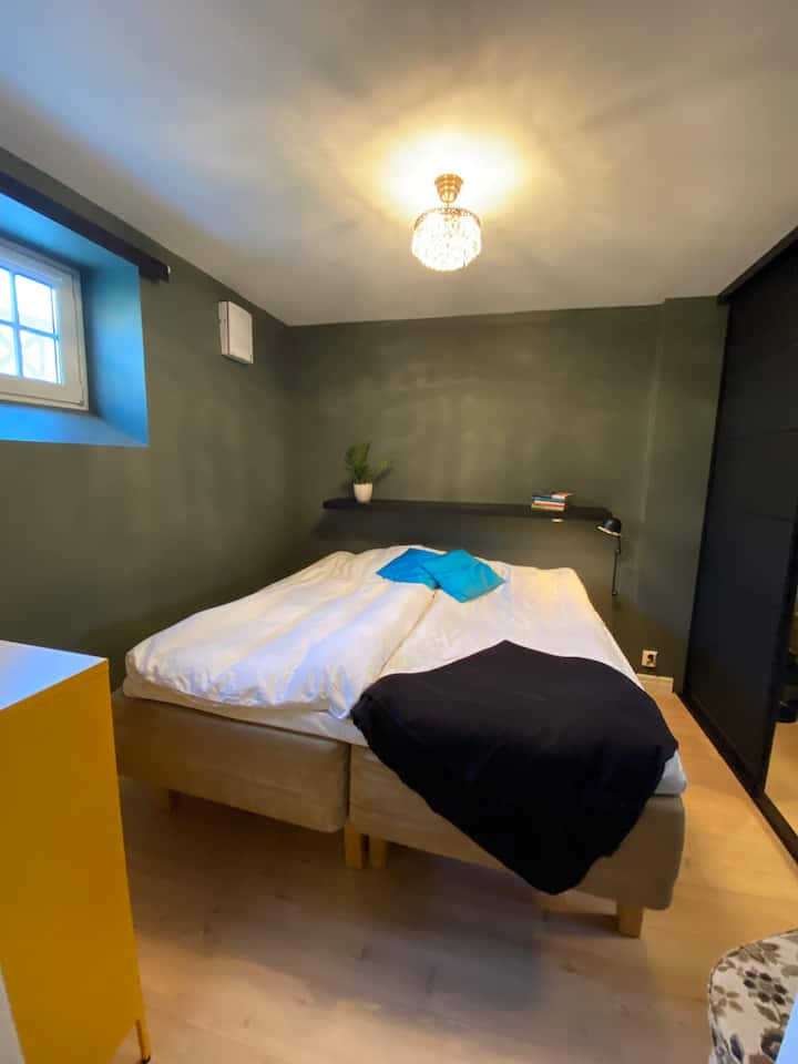 Chumba kikuu cha kulala kwenye ghorofa ya chini chenye kitanda chenye upana wa sentimita 180. 