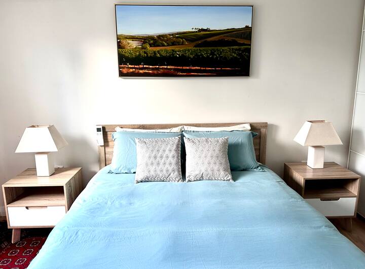 Над двойното легло виси произведение на Норм Уилсън. 